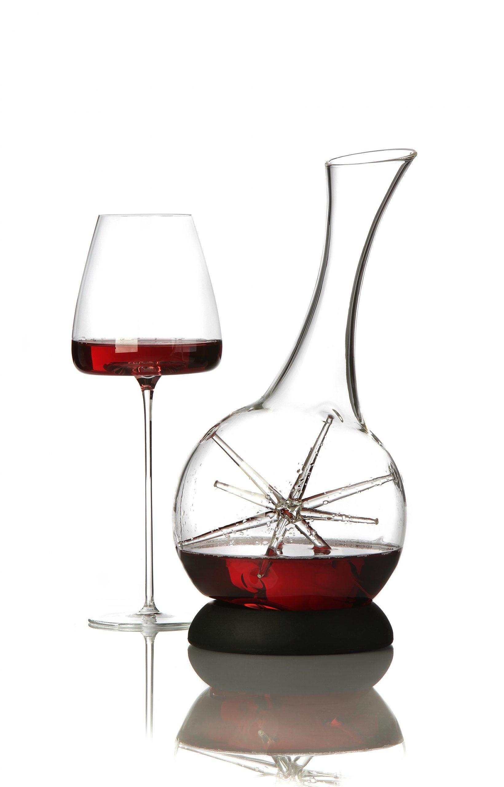 Zieher karaffel Star med silikonebase og rødvin i karaflen står ved siden af et Zieher vinglas fyldt med rødvin. Karaflen er fremstillet af mundblæst borosilikatglas og har en indre stjerneform, der sikrer jævn iltning af vinen.