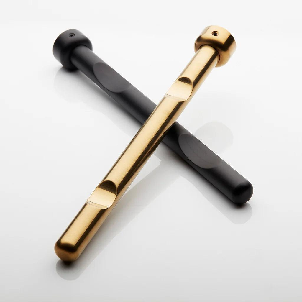 To vinholderpinde i guld og sort, krydset på en hvid baggrund. Pindene har et elegant og moderne design med runde ender.