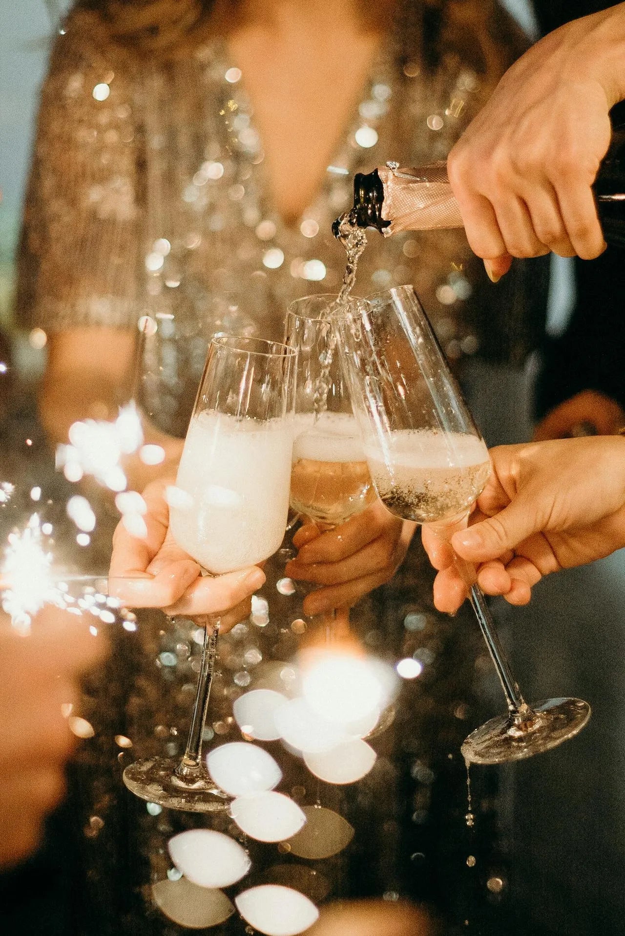 Nærbillede af champagneglas, der bliver fyldt og hævet i en skål.